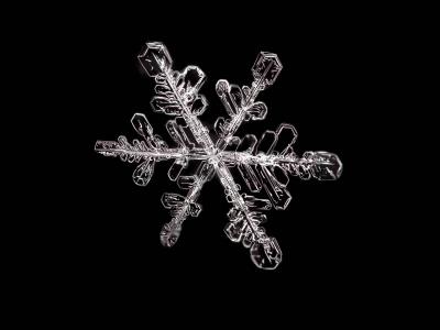 Single snowflake on black background.