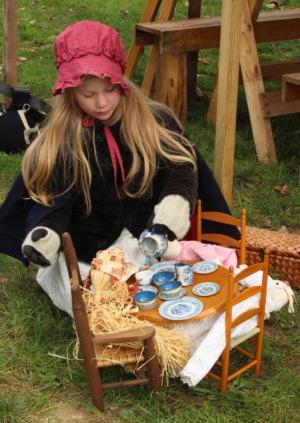 young girl playing with tea set 