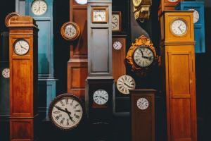 A room full of tall clocks in varying colors.